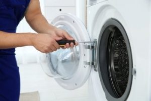 Image depicts a HandiFix Appliance Repair technician repairing a dryer.